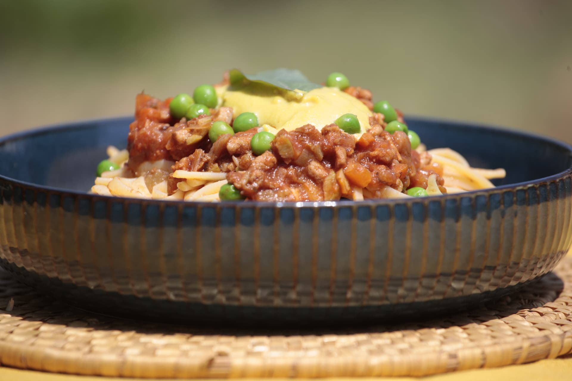 Plant-based bolognese pasta with peas and saffron cream